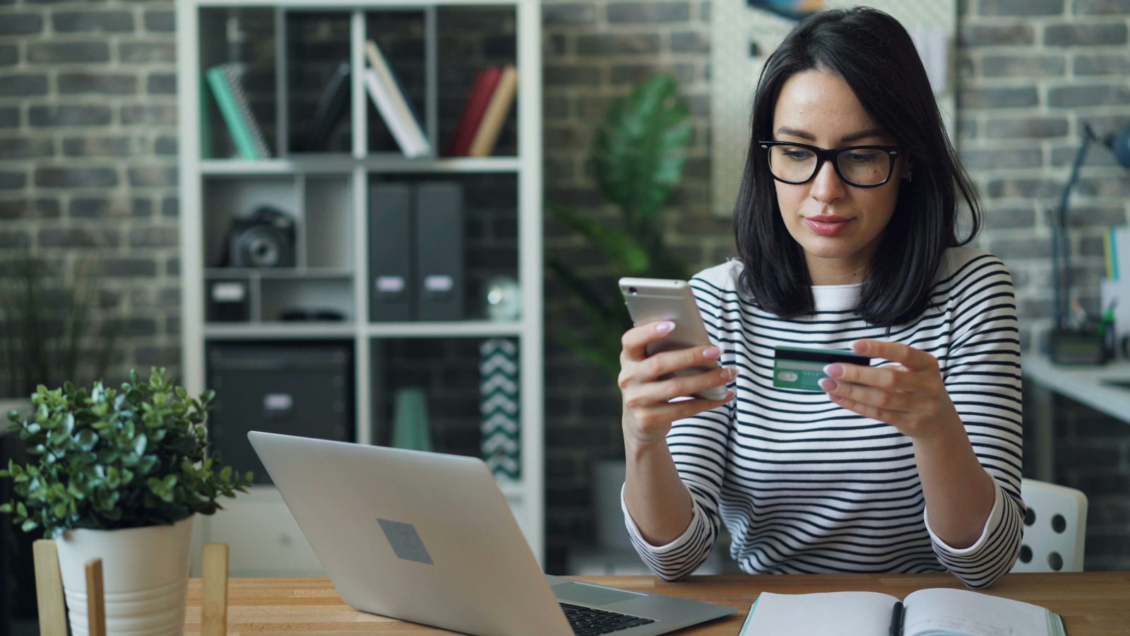 Booking on a phone with a laptop nearby