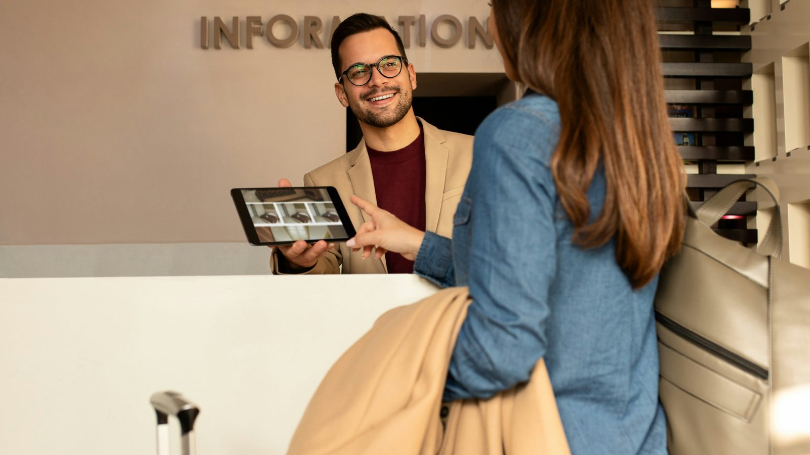 A reception desk with staff and a tablet