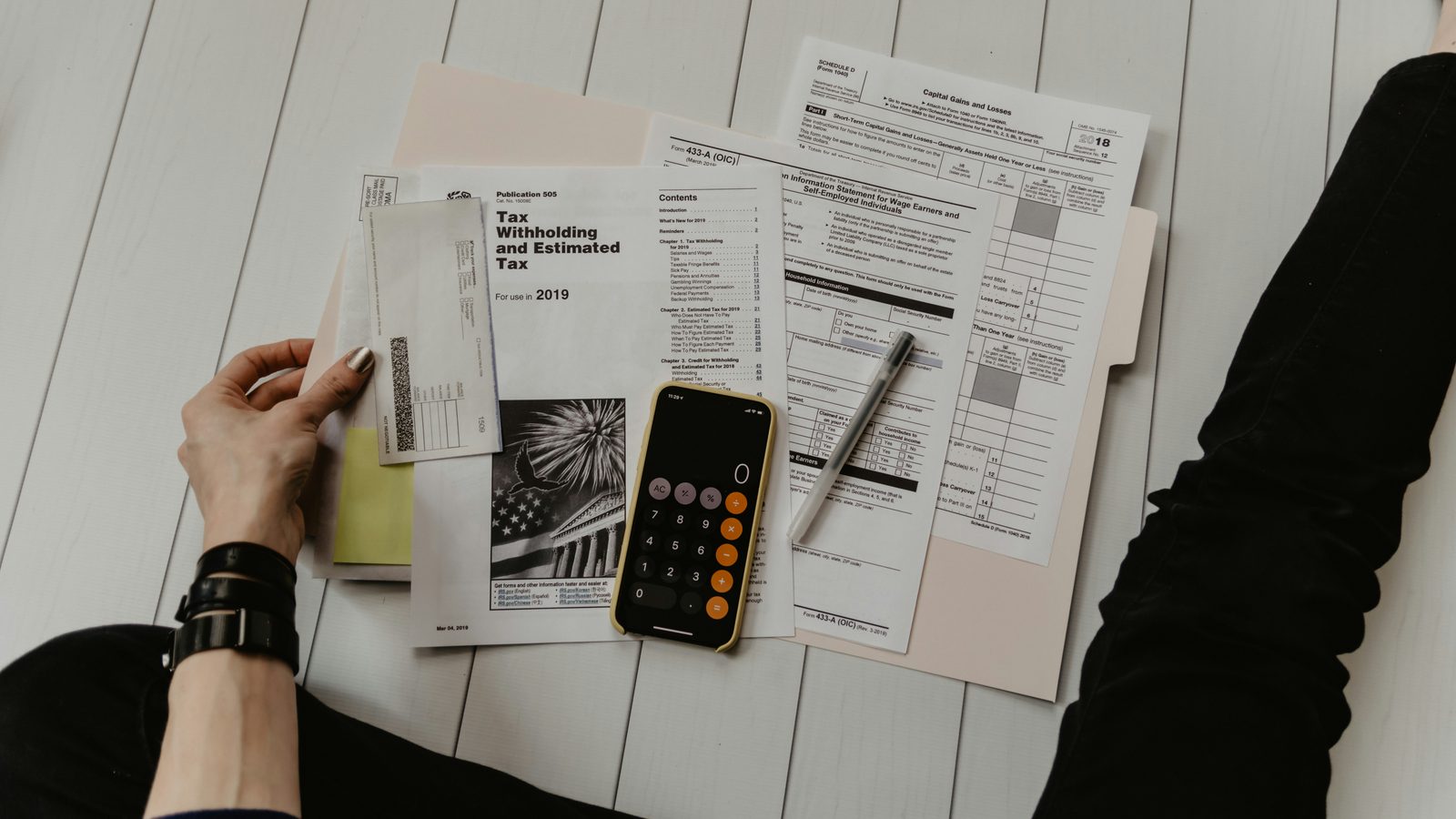 Tax forms, a calculator and a phone on a desk